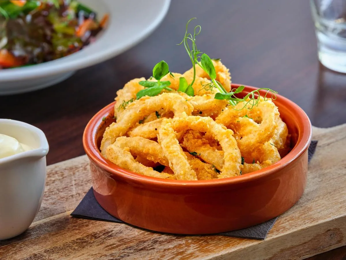 a bowl of onion rings on a wooden table at AC Hotel by Marriott Belfast in Belfast