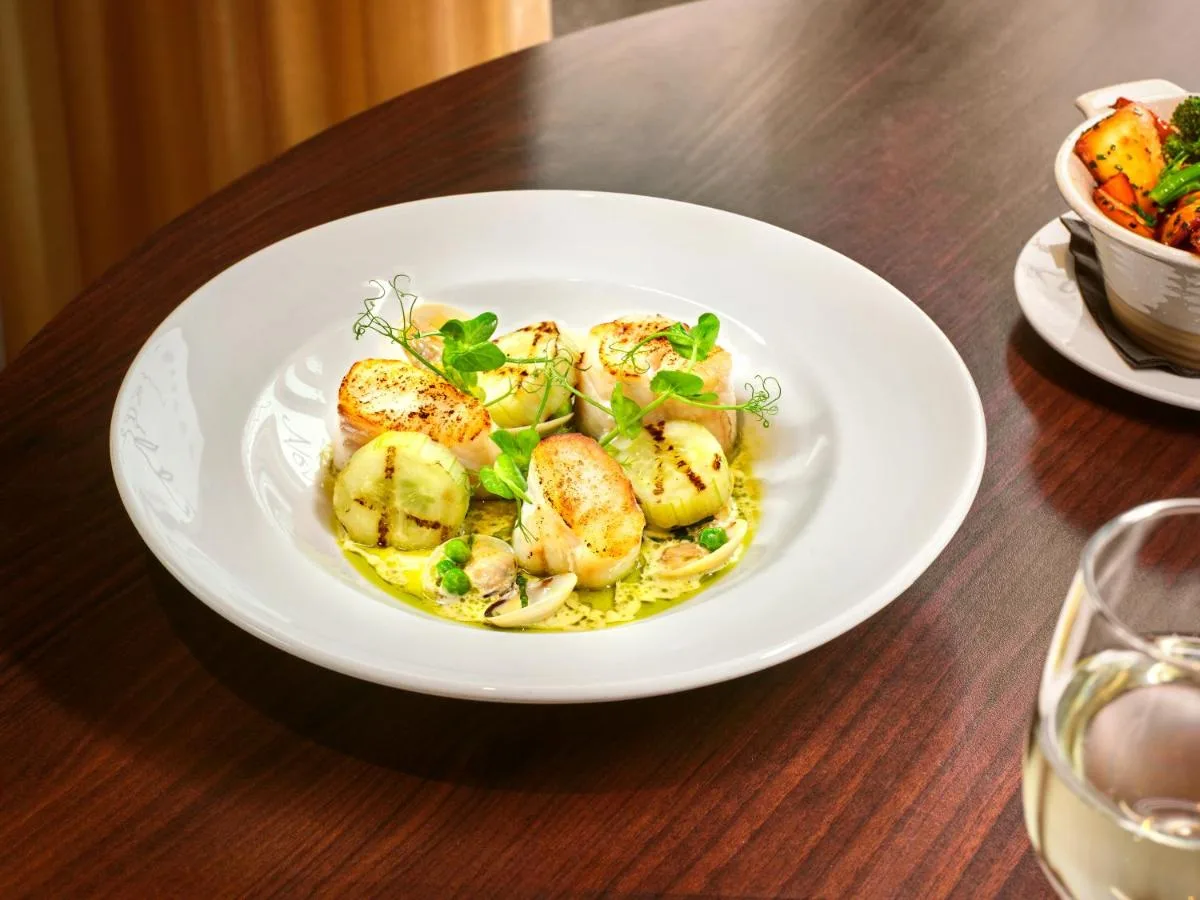 a white plate of food on a wooden table at AC Hotel by Marriott Belfast in Belfast