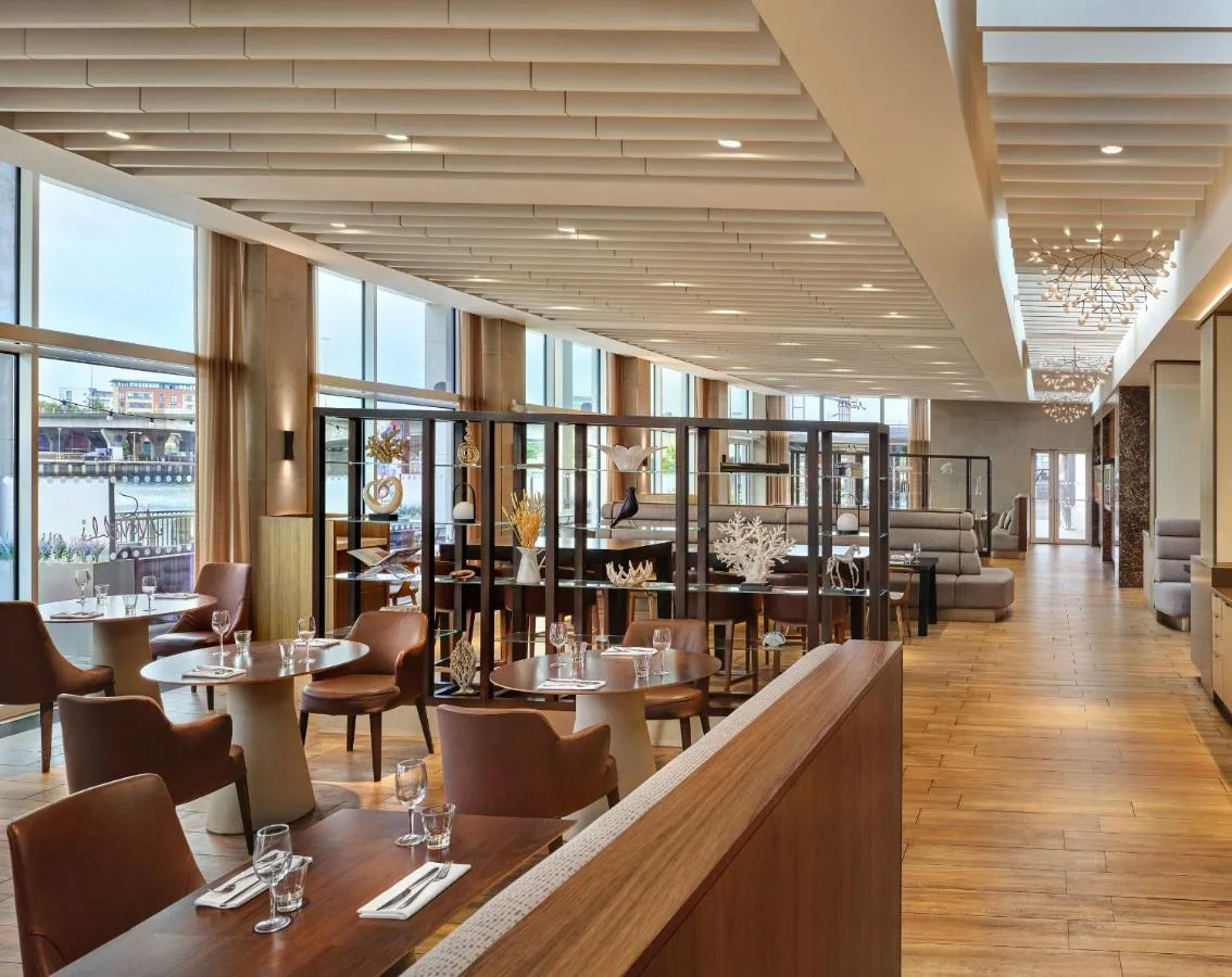 a restaurant with tables and chairs and windows at AC Hotel by Marriott Belfast in Belfast